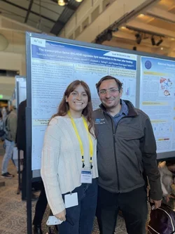 PhD Candidate Gabriella Rubert standing in front of poster presentation at DOM Research Day