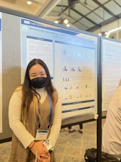 Student standing in front of poster presentation.
