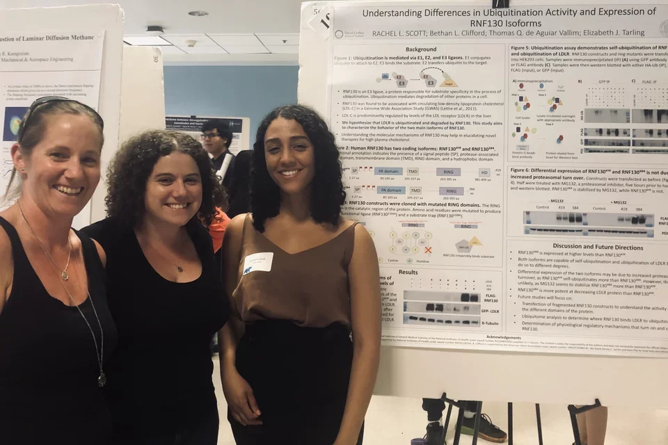 Rachel and two other women in front of poster presentation