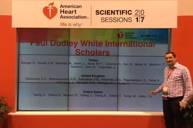 Man standing in front of Paul Dudley White International Scholar sign