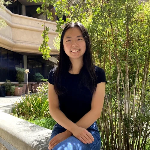 Meigan Wu sitting outside by tree
