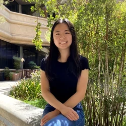 Meigan Wu sitting outside by tree