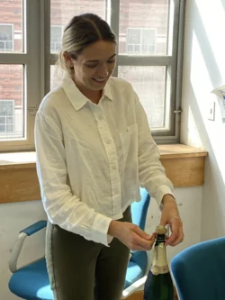  PhD Candidate Emily Smith opening champagne bottle