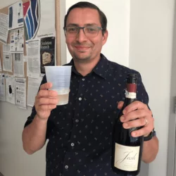 Tom holding bottle of champagne to celebrate tenure