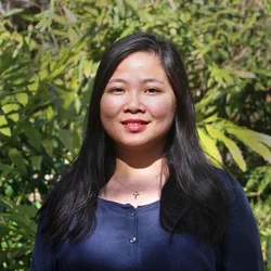Joan Cheng standing by trees